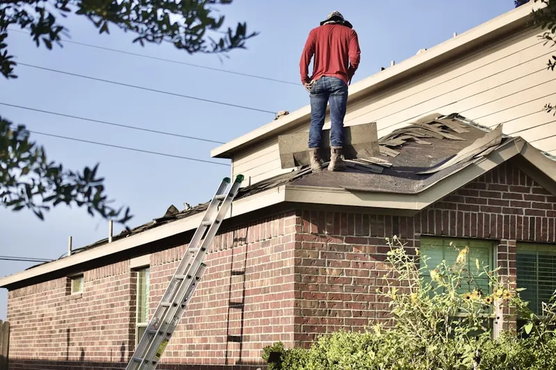 Professional roofer working on a residential roof in Pittman